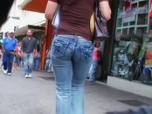 Hot body girl in tight jeans walking the street with a voyeur behind her