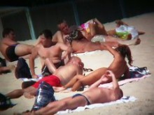 Voyeur en la playa capturando a una chica bronceada y desnuda