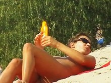 Una mujer deliciosa tomando el sol en este vídeo voyeur de playa nudista