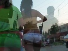 Chicas calientes en pantalones cortos muy cortos caminan por la calle antes de